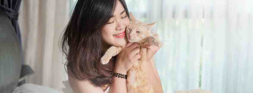 Woman snuggling an orange cat