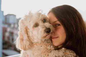 Young woman hugs a shaggy blonde dog