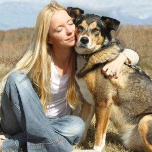 Young woman hugs her German Shepherd dog