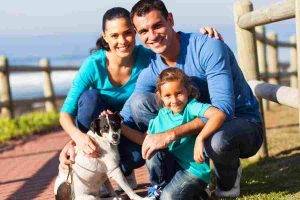 Small canadian family and their dog by the walking by the ocean